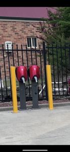 two parking meters in front of a fence at Ambassador Orange in Orange