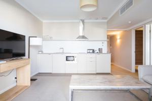 a kitchen with white cabinets and a table at The Marina Hotel - Mindarie in Mindarie
