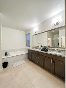 uma grande casa de banho com 2 lavatórios e uma banheira em 4 Bedroom Pet Friendly Retreat with King Bed em Rancho Cordova