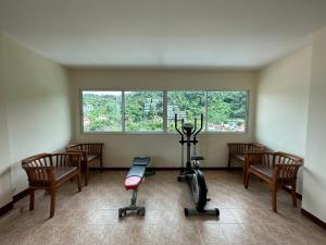 a room with a gym with chairs and an exercise bike at Kata Place Hotel in Kata Beach
