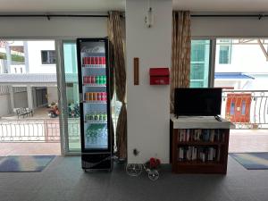 a drink refrigerator in a living room with a tv at Kata Place Hotel in Kata Beach