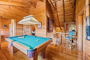 ein Billardtisch in einem Zimmer in einer Hütte in der Unterkunft Bearfoot Pines - True Log Cabin - Wi-Fi, Hot Tub, Fishing, Deck with views! - Mins to PF in Sevierville