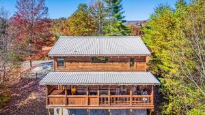 eine Aussicht über eine Blockhütte im Wald in der Unterkunft Bearfoot Pines - True Log Cabin - Wi-Fi, Hot Tub, Fishing, Deck with views! - Mins to PF in Sevierville