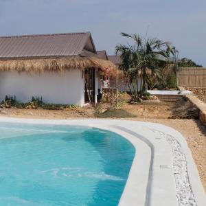 uma piscina em frente a uma casa em Solimar Seaside Cabanas em Tambobong