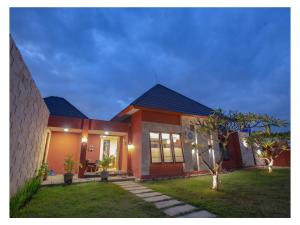 een huis met een gazon ervoor bij Dawn Light Villa, Sire in Tanjung