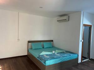 a small bedroom with a bed with blue sheets at White Rose Guesthouse in Koh Rong Island