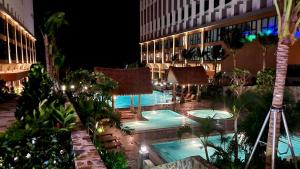 un hôtel avec une piscine et un bâtiment dans l'établissement APEC MANDALA KOLYA Building D, à Phan Thiết