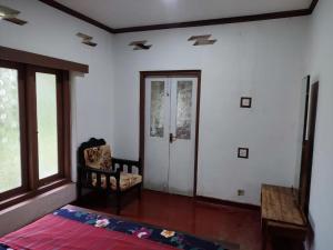 a room with a bed and a chair and a door at The Duke in Weligama