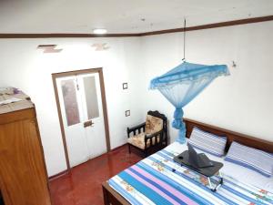 a bedroom with a bed with a blue umbrella on it at The Duke in Weligama