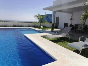 a swimming pool with two chairs and a table at V&G Las vacaciones que mereces in Ursulo Galván