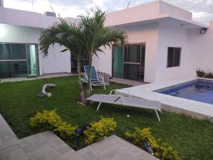 un patio trasero con piscina y una casa con palmeras en V&G Las vacaciones que mereces, en Ursulo Galván