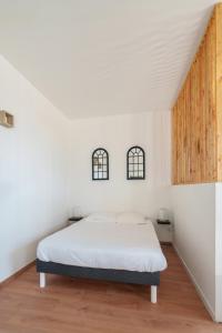 1 dormitorio con 1 cama y 2 ventanas en Le Lotus - ZMN Conciergerie en Saint-Quentin