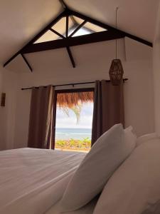 um quarto com uma cama e vista para o oceano em Solimar Seaside Cabanas em Tambobong