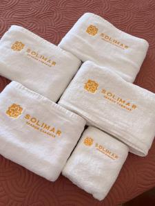 quatro toalhas brancas com santana escrita nelas em Solimar Seaside Cabanas em Tambobong