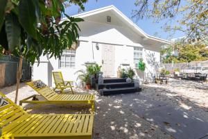 een wit huis met gele stoelen ervoor bij Home Miami - Wynwood area with backyard - Art District near to Beach in Miami