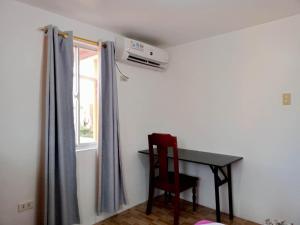a room with a table and a chair and a window at Noana Crib in Davao City