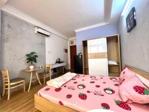 ein Schlafzimmer mit einem Bett und einem Tisch sowie eine Küche in der Unterkunft Le Nhim Homestay in Ho-Chi-Minh-Stadt