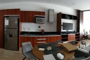 a kitchen with a table and a kitchen with a refrigerator at El mejor Departamento en Mérida in Mérida