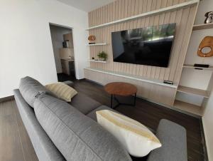 a living room with a couch and a flat screen tv at El mejor Departamento en Mérida in Mérida