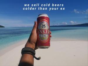 KriにあるMansuar Raja Ampat Bungalowsの浜辺の缶ビールを持つ者