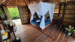 een kamer met een bed met een klamboe bij Mansuar Raja Ampat Bungalows in Kri