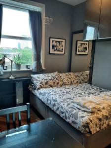 a bedroom with a bed and a desk and a window at Sabellis House - Moments from the Big Ben in London