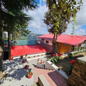 vista su una casa con tetto rosso di Himalayan Havenwood a Mukteshwar