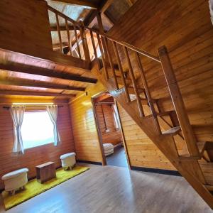 穆克缇斯瓦Himalayan Havenwood的阁楼间,设有木楼梯,位于小屋内