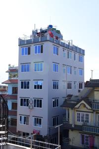 a tall white building with a lot of windows at Hotel Global Village in Kathmandu
