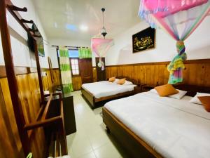 a room with two beds and two windows at Srilak View Holiday Inn in Haputale