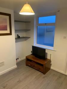 a living room with a flat screen tv on a wooden table at Arden Street in Gillingham