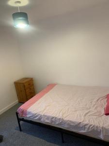 a bedroom with a bed and a wooden dresser at Arden Street in Gillingham