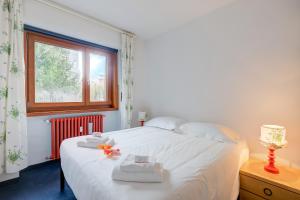 a bedroom with a white bed with towels and a window at Terrazza Dei Principi Few Steps From Ski - Happy Rentals in Sestriere