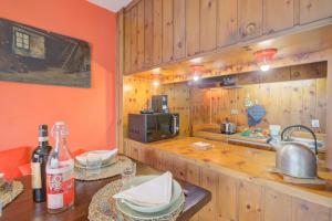 a kitchen with wooden cabinets and a counter with a sink at Terrazza Dei Principi Few Steps From Ski - Happy Rentals in Sestriere