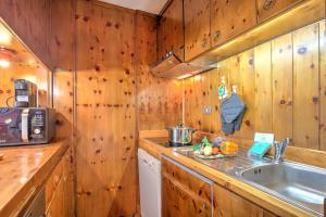a kitchen with wooden walls and a sink and a microwave at Terrazza Dei Principi Few Steps From Ski - Happy Rentals in Sestriere