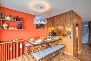 a kitchen with orange walls and a table with chairs at Terrazza Dei Principi Few Steps From Ski - Happy Rentals in Sestriere