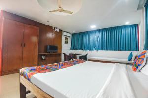 a hotel room with two beds and a tv at FabExpress Stargaze Beach in Anjuna