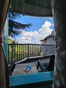 Blick aus dem Fenster eines Balkons mit einem Tisch in der Unterkunft Himalayan Havenwood in Mukteswar