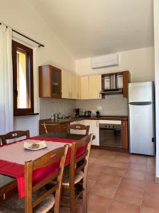 Il comprend une cuisine équipée d'une table et d'un réfrigérateur blanc. dans l'établissement Casa Vacanze "Dimora Quercia" - Appartamento "Quercia", à Montefalco