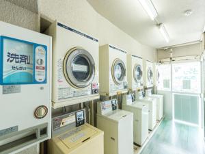 una lavanderia con fila di lavatrici di HOTEL Nishikawaguchi Weekly - Vacation STAY 43454v a Saitama