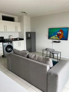 sala de estar con sofá y cocina en Dmn City Apartment at Junction en Windhoek