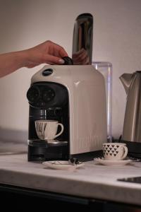 Une personne utilise un grille-pain sur un comptoir de cuisine. dans l'établissement Gallery Suite the Turin center apartment 5 Floor, Free garage, Big terrace, à Turin 19 autres photos