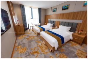 Habitación de hotel con 2 camas y TV en Phú Long Tam Kỳ Hotel & Restaurant en Tam Kỳ