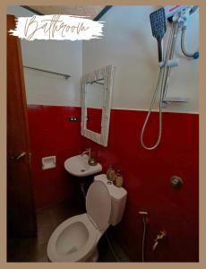 a bathroom with a toilet and a sink at Hidden of Cailan Extension Transient House in El Nido