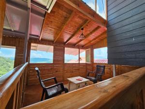 a room with two chairs and a table in a cabin at Himalayan Havenwood in Mukteshwar