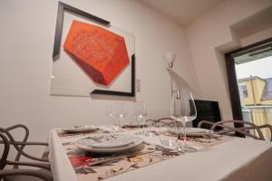 - une table à manger avec des verres à vin et une peinture dans l'établissement Gallery Suite the Turin center apartment 5 Floor, Free garage, Big terrace, à Turin