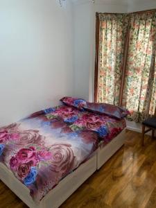 a bedroom with a bed with a floral comforter at Gordon Road in Gillingham