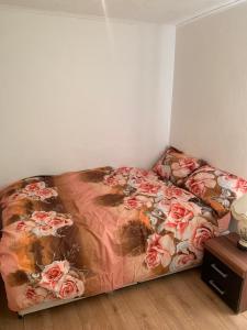 a bed in a room with a bedspread with roses at Gordon Road in Gillingham