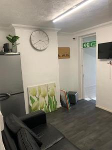 a living room with a clock on the wall at Gordon Road in Gillingham