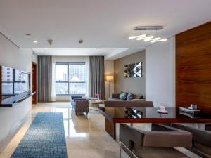 a living room with a couch and a table at Flora Al Barsha Hotel At The Mall in Dubai